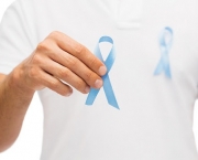 medicine, health care, gesture and people concept - close up of male hand holding blue prostate cancer awareness ribbon