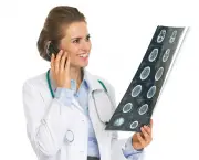 Smiling doctor woman with fluorography talking cell phone